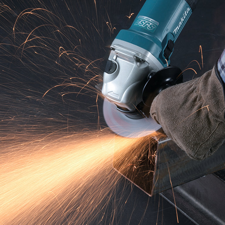 Amoladora Makita GA5040RZ realizando corte en metal con chispas y sistema SJS II de reducción de vibraciones.