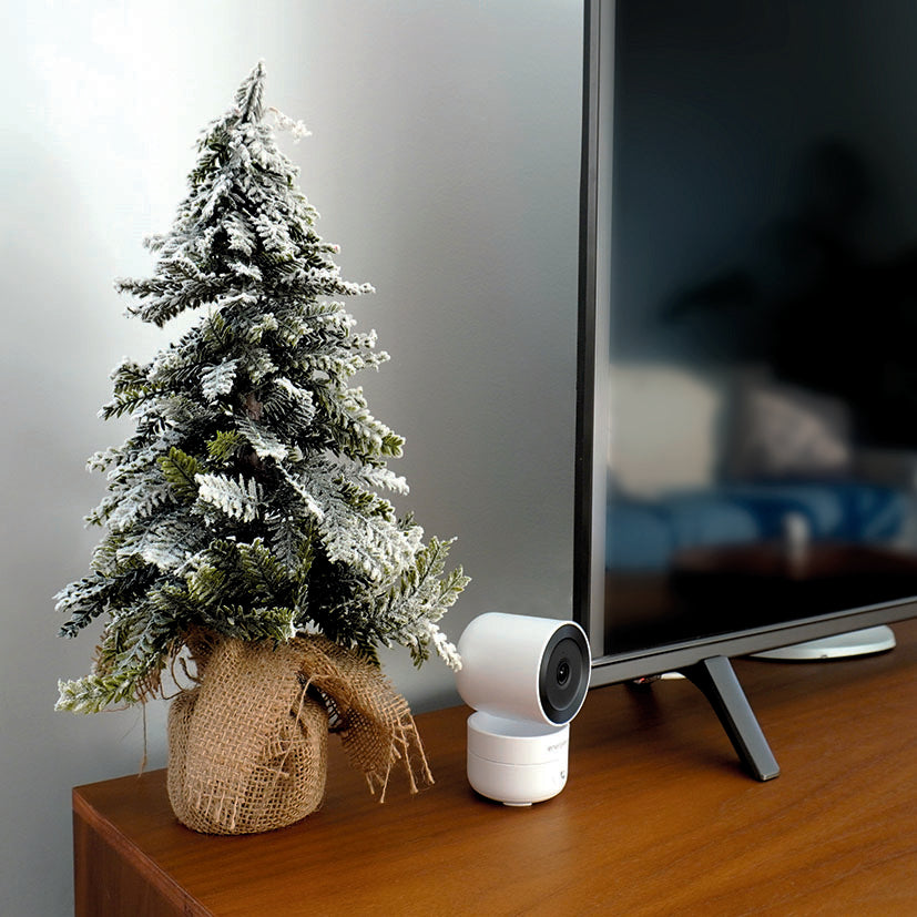 Cámara Energeeks Sentinel Pro instalada de forma discreta en un mueble de salón junto a un televisor