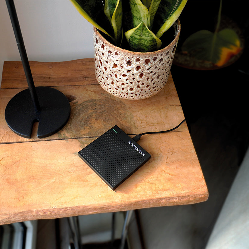 Central de alarma inteligente Energeeks conectada a corriente sobre mesa de madera en ambiente doméstico