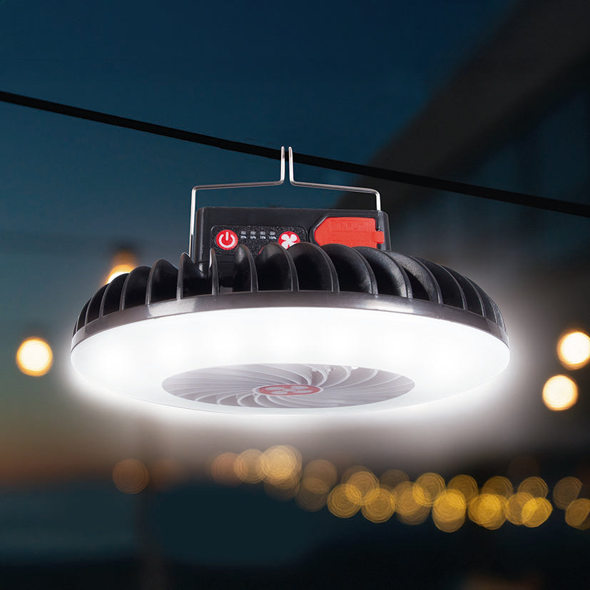 Ventilador solar portátil HABITEX iluminando una zona exterior nocturna colgado de un cable de camping.