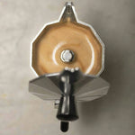 Primer plano superior de cafetera moka Oroley con café espresso recién preparado y espuma