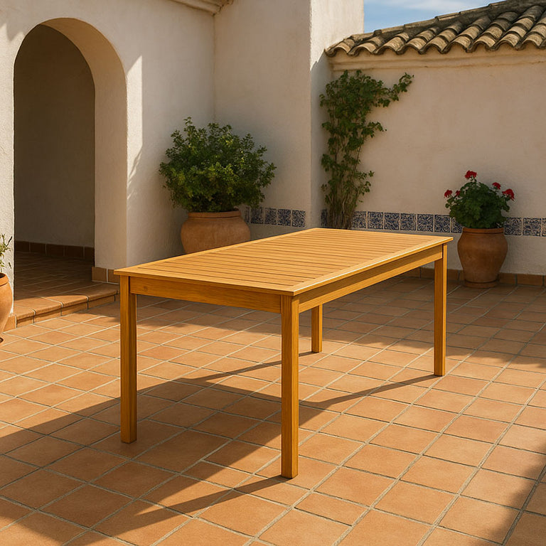 Mesa de exterior LEVU de madera natural para 8 personas en un patio decorado con plantas y macetas.