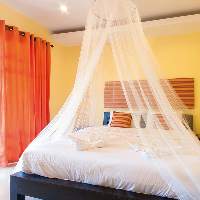 Mosquitera blanca para cama doble marca LISTA instalada sobre cama de matrimonio en dormitorio