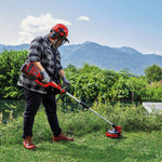 Hombre utilizando la desbrozadora Einhell 36V para cortar hierba alta en un entorno natural cerca de un río.