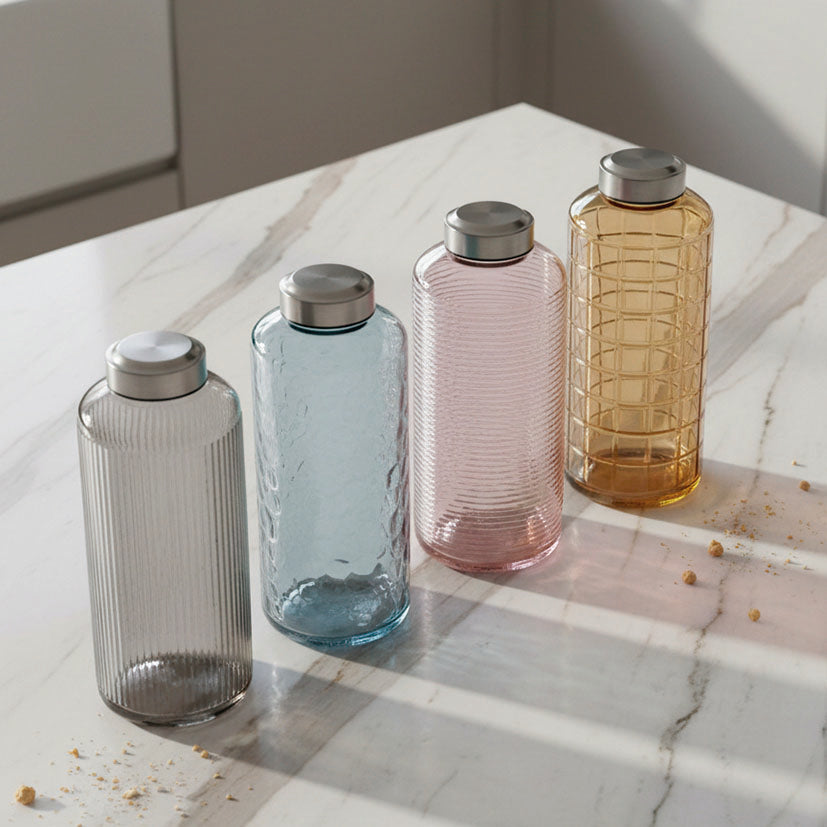 Botellas de vidrio decorativas sobre mesa de mármol mostrando reflejos y texturas.