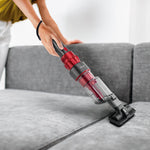 Aspirador UFESA UH5 en uso sobre un sofá gris utilizando el accesorio de cepillo ancho para tapicerías.