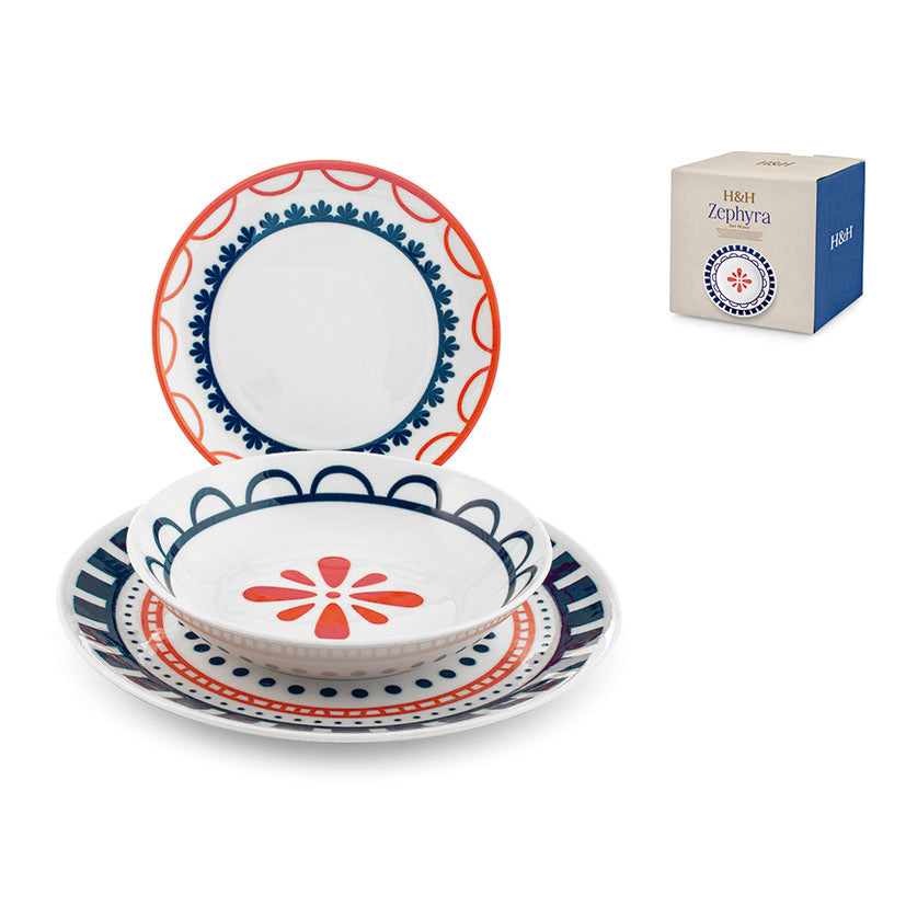 Vajilla de porcelana PENGO modelo Zephyra con motivos ornamentales en azul y rojo sobre fondo blanco.