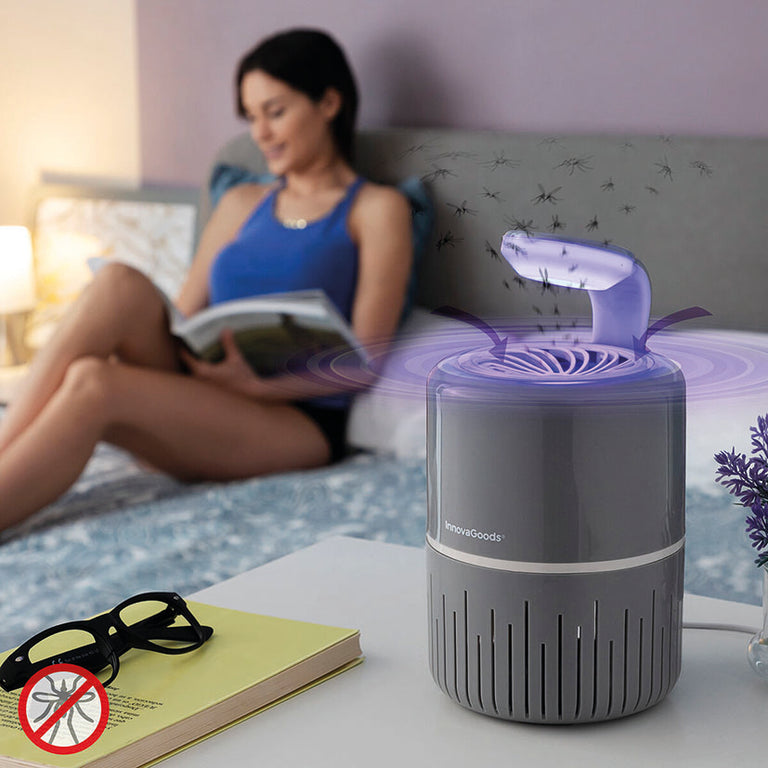 Lámpara antimosquitos InnovaGoods en mesita de noche con mujer leyendo en la cama