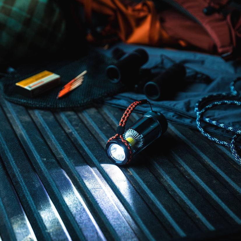 Lámpara de camping NEBO Galileo Tempest 350 iluminando una superficie metálica en modo linterna